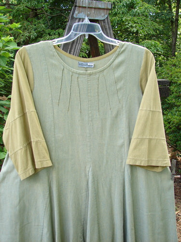 Barclay Playdate Sunrise Spin Dress Unpainted Spice Size 1. Displayed on a swing, highlighting its unique rolled neckline, mega sectional skirt panels, and sweeping lower shape, perfect for showcasing vintage Blue Fish style.