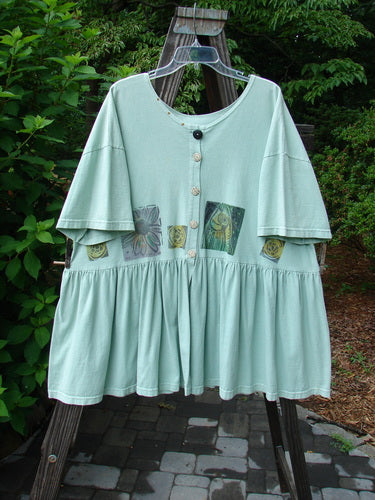 1992 Studio Cardigan Dress Fish and Flower Green Tourmaline OSFA featuring flouncy front vent, gathered waistline, vintage buttons, and bold flower design, embodying Blue Fish's vintage creativity and unique style.