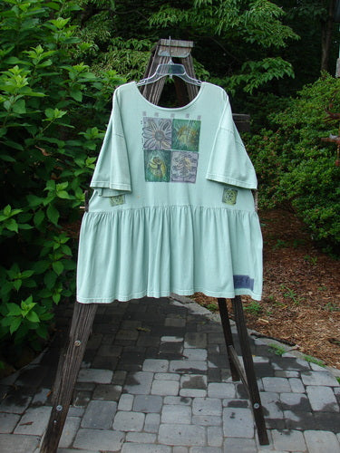 1992 Studio Cardigan Dress Fish and Flower Green Tourmaline OSFA displayed on a hanger, showcasing vintage buttons, flouncy bottom, and bold fish and flower paint.