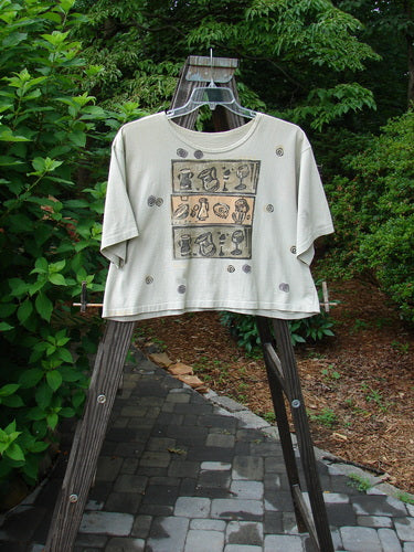 1991 Short Sleeved Oversized Tee Pitcher Glass Wheat OSFA displayed on a rack, showcasing its super wide boxy cut and vintage goblet theme paint, part of the 1991 Summer Collection.