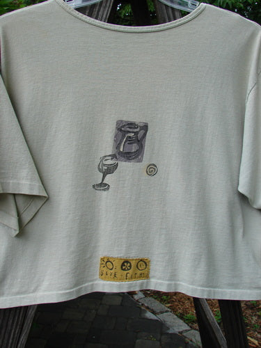 1991 Short Sleeved Oversized Tee Pitcher Glass Wheat OSFA featuring a vintage goblet design, wide boxy cut, rounded neckline, and blue fish patch, made from mid-weight cotton.