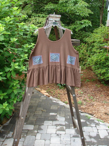1992 Patched Peplum Top Happy Face Mushroom OSFA displayed on a wooden ladder, featuring a yoke waist seam, rounded neckline, high arm openings, wide waist, and a flounced bottom with a star patch.