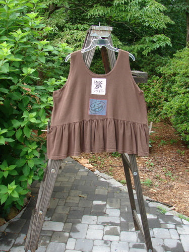 1992 Patched Peplum Top Happy Face Mushroom OSFA on a wooden rack, featuring a downward yoked waist seam, rounded neckline, higher arm openings, and a large gathered bottom flounce with a center back star patch.