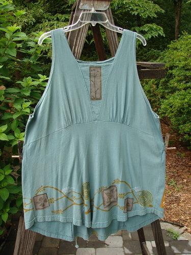 1993 Cha Cha Jumper Grey Green OSFA: A blue dress on a clothes rack, featuring a squared off neckline, A-line flare, empire waist seam, and block prints in a branch and swirl theme.