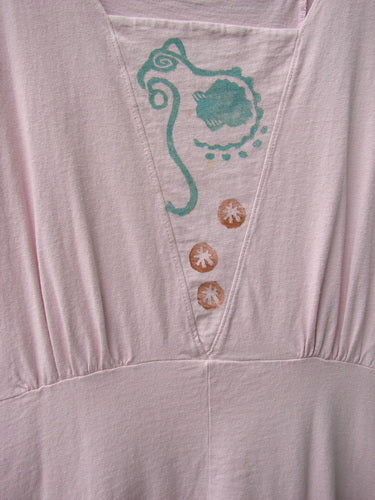 1993 Cha Cha Jumper Seashell Ash Pink OSFA: A close-up of a pink shirt with a square neckline, gathered bust area, and seashell and swirl block prints.