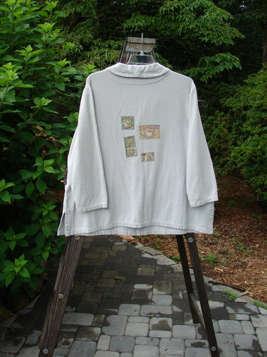1999 Patched Flannel PJ Top Blue Horizon Size 0 displayed on a hanger, showcasing a cozy flannel fabric with drop shoulders, vented sides, an A-line shape, and multiple front and rear patches.