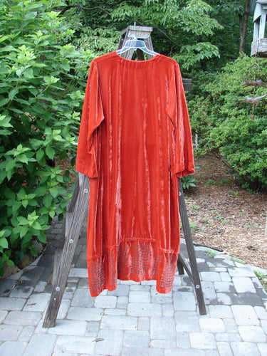 2000 NWT Silk Velvet Templeisen Gown Starlight Sienna Size 1 displayed on a wooden swing, showcasing its elegant drape, unique snap-on hemline, V-neckline, and belled sleeves.