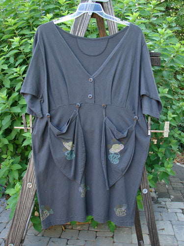 1994 Muse Dress Celestial Planet Blue Coal Size 1 on a clothes rack, featuring deep V neckline, teardrop pockets with buttons, and 3/4 inch sleeves, highlighting Blue Fish’s vintage design.