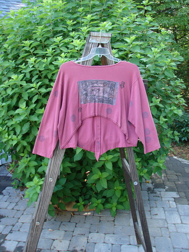 1994 Curve Shirt Studio Umeboshi Size 1: A pink shirt on a clothes rack, featuring a varying hemline and a V-shaped neckline. Original Blue Fish buttons. A true collector's wonder!