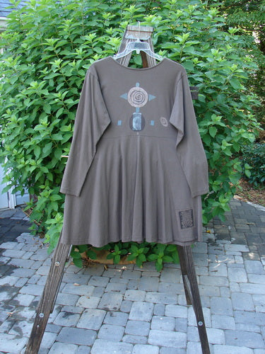 1994 Poppy Dress Collarless Figure Eight Woman Humus Size 2 displayed on a swing, showcasing its empire waist, full sweeping lower, vintage buttons, and signature Blue Fish patch.