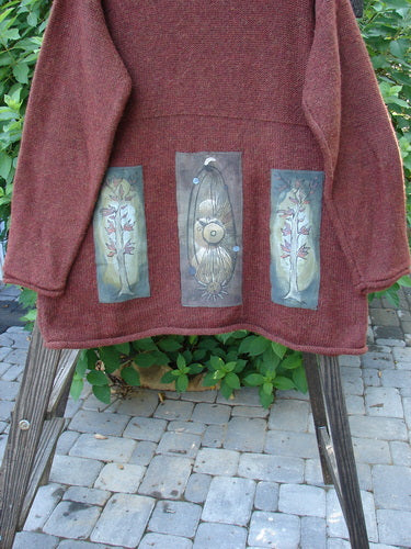 1998 Alpaca Patched Simple Tunic Sweater Autumn Fall Sprig Tweed OSFA displayed on a wooden swing outdoors, showcasing its ribbed mock collar, nature-themed patches, and oversized, textured knit design.