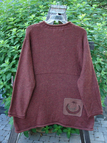1998 Alpaca Patched Simple Tunic Sweater Autumn Fall Sprig Tweed OSFA displayed on a wooden swing, showcasing its rolled mock collar, ribbed sleeves and hemline, oversized patches, and Blue Fish signature patch.