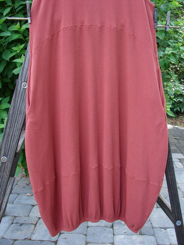 Barclay Thermal Teapot Jumper Unpainted Pomme Size 1 displayed on a wooden stand, showcasing its cozy ribbed waffle fabric, deep side pockets, and unique belled varying hemline.