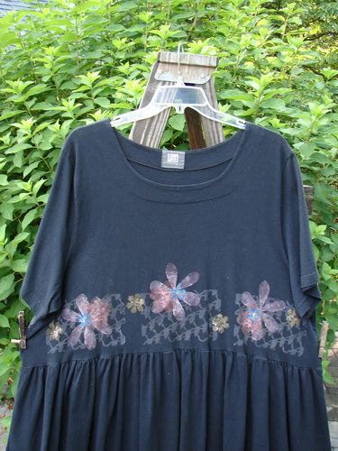 2000 Rosalee Dress Continuous Floral Black Size 2: Black babydoll dress with vibrant floral patterns, dropped waistline, scooped neckline, and sweeping lower hem from Bluefishfinder.com's vintage collection.