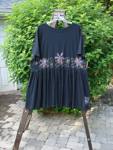 2000 Rosalee Dress Continuous Floral Black Size 2, displayed on a wooden swing, features a dropped waistline, sweeping lower, scooped neckline, and floral theme bodice paint.