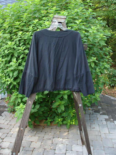 2000 Flannel Zantia Jacket Bubble Block Black Size 2 displayed on a clothes rack, showcasing its boxy square shape, paneled sleeves, belled hemline, and whimsical ruffled layers.