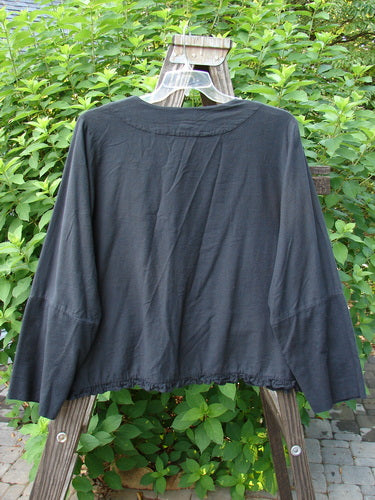 2000 Flannel Zantia Jacket Bubble Block Black Size 2 displayed on a wooden hanger, showcasing its ruffled panels, boxy square shape, belled hemline, and colorful wheel-themed paint with matching metal buttons.