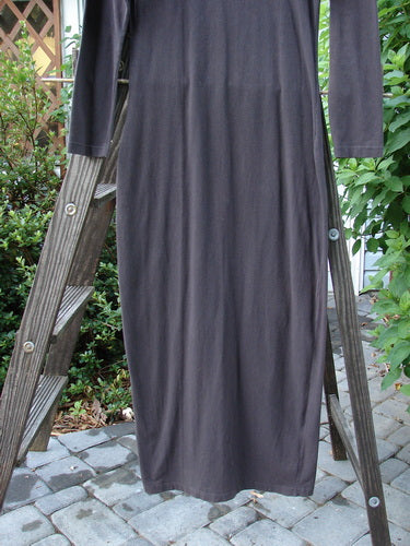 1992 Cotton Lycra Back Vent Dress Unpainted Black Olive Size 2: A long dress on a ladder, featuring a black dress with a patterned design. Perfect for layering, it has a tiny hourglass shape, a rear kick vent, and a deeper V neckline. A true collector's piece from the limited Blue Fish Exclusive collection.