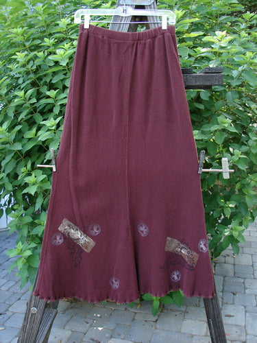 1996 Thermal Swirl Skirt Moon Cayenne Size 2 on a clothes rack, showcasing its full elastic waistline, A-line flair, and vertical sectional panels with abstract paint accents.