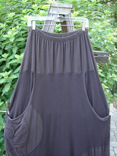 Barclay Thermal Celtic Moss Panel Pocket Circle Skirt Unpainted Darker Bark Size 2 hanging on a clothesline, showcasing its full elastic waistline, deep front pockets, and alternating circle patches.