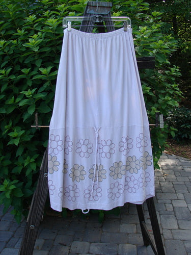 Barclay Spring Shade Skirt Circle Center Pale Pink Size 2 displayed on a rack, featuring floral patterns and vertical loops for creative adjustments, made from organic cotton with a full elastic waistband.