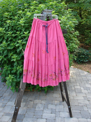 Barclay Linen Drawstring Ruffle Skirt Daisy Fence Flamingo Size 2: A ruffled skirt with a drawstring waistline, alternating horizontal seams, and a billowy flare. Features sweet fringe edges and a daisy fence pattern.