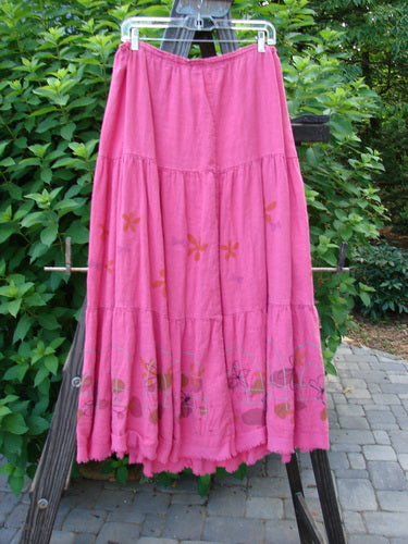 Barclay Linen Drawstring Ruffle Skirt Daisy Fence Flamingo Size 2 displayed on a rack, showcasing its full drawstring waistline, horizontal seams, A-line shape, and sweet fringe edges.