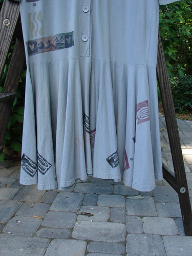 1994 Column Dress Heart Solstice Blue Size 1 displayed on a rack, showcasing its full front button design, V-shaped neckline, and longer sleeves.