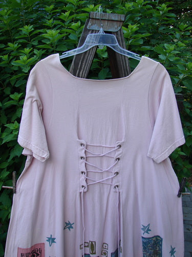 1993 Jazz Dress Star Leaf Ash Pink Size 1, featuring a wide A-line shape, triangular neckline, rear lace-up design, and distinctive 1993 Blue Fish Patch, displayed on a wooden swing.