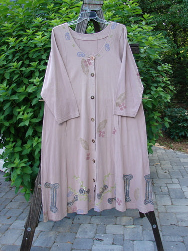 1993 Modernismo Duster Dress Columns Ash Pink OSFA on clothes rack with vintage column and leaf design, kangaroo pockets, scooped neckline, and wooden buttons, showcasing its unique and collectible features.