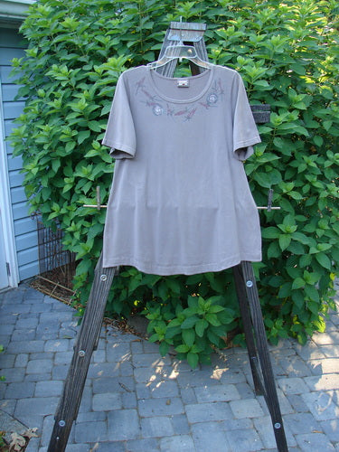 Barclay Cotton Lycra Short Sleeved Twinkle Top Necklace Mauve Size 0: A swingy t-shirt on a clothes rack with a design on it.