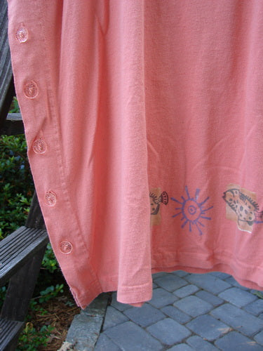 1997 Mauritius Top Fern Fish Tangerine OSFA: Pink shirt with sun and fish designs, featuring clear floral buttons, tall side vents, and a slight bell shape. Made from mid-weight organic cotton.