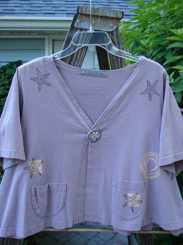 1997 Cove Jacket Star Fish Coral Reef Jasmine Size 1, featuring a purple star-patterned design, V-shaped neckline, porcelain button closure, and two front rounded pockets. Flared, cropped A-line shape.