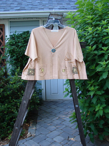 1997 Cove Jacket Sea Life Driftwood Size 1 displayed on a wooden rack, showcasing its flared, cropped A-line shape, V-shaped neckline, and distinctive handmade porcelain closure with a sea life design.