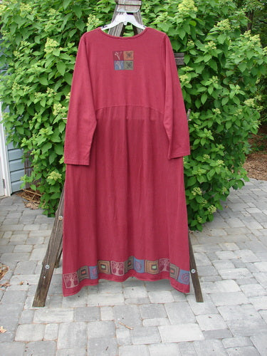 Barclay Hemp Cotton Curved A Line Dress Tree of Life Hollyberry Size 2 displayed on a wooden hanger, showcasing its long length, wide A-line shape, and detailed hem pattern.