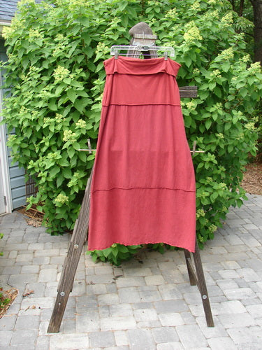 Barclay Hemp Cotton Decora Fold Over Skirt Unpainted Brick Size 2 displayed on a clothes rack, showcasing its full A-line shape and horizontal piping details.