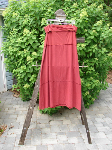 Barclay Hemp Cotton Decora Fold Over Skirt Unpainted Brick Size 2 displayed on a wooden stand, showcasing its A-line shape and detailed stitching.