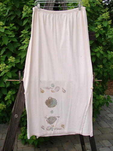 Image alt text: "1994 Panel Skirt with Daisy Lane design, featuring a white towel with seashells on a clothesline, a wood post, and a plant."