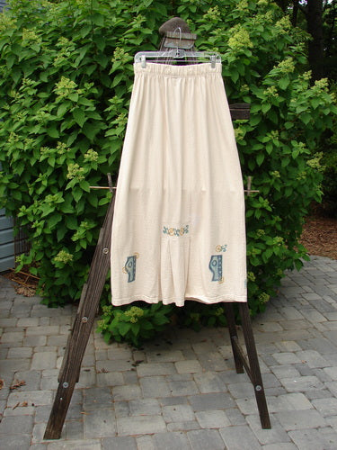 1995 Kick Skirt Resort Travel Champagne Size 2, featuring a full elastic waistband, kick pleat, and scooped hemline, displayed on a rack against an outdoor backdrop.