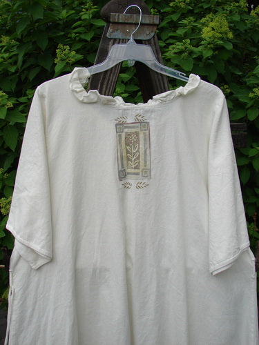 Barclay Linen Duet Sunrise Dress Fern Circle Flower Creme Size 2, featuring floral designs, curly neckline, vertical pleats, painted pockets, and a varying hemline, made from lightweight cotton-linen.