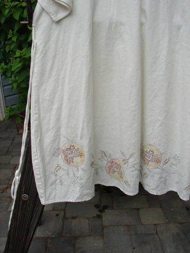 Barclay Linen Duet Sunrise Dress Fern Circle Flower Creme Size 2, showcasing a floral and fern circle design, ruffled neckline, and painted pockets, in a lightweight, tightly woven linen fabric.