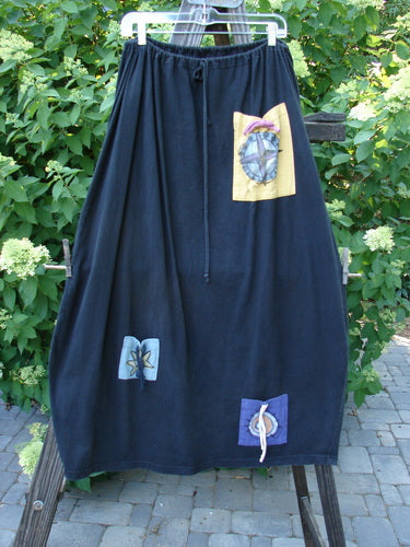 1996 Destination Skirt: A long black skirt with patchwork design, drawstring waist, painted pockets, Blue Fish logo patch, and widening bell shape.
