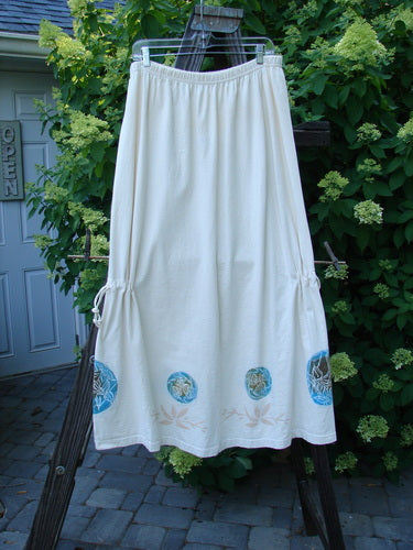 1999 Tie In Skirt Leaf Medallion Natural Size 2 features a white skirt with a blue floral leaf medallion pattern, full elastic waistband, and adjustable draw cords, made from organic cotton.
