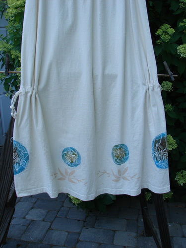 1999 Tie In Skirt Leaf Medallion Natural Size 2, featuring an elastic waistband, draw cords, and unique sectional panels with detailed leaf medallion paint, displayed on an outdoor stone walkway.