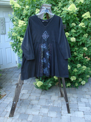 1997 Jester's Dress Moon Celtic Obsidian Size 2 on a wooden stand, featuring a V cross-stitched neckline, A-line shape, and Celtic moon theme paint.