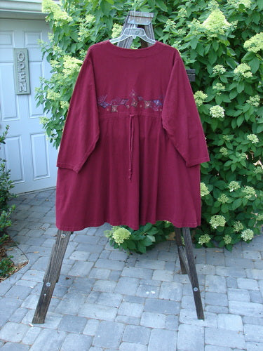 Image: A red jacket with a diamond trail pattern, hanging on a rack. 

Description: 1997 Mask Jacket Diamond Trail Regalia Size 2. This swing piece is made from mid-weight cotton and features a bell shape with a special button closure, deep side pockets, and a rounded swing hemline. The jacket has a slightly raised drawcord back and is in perfect condition. Bust 50, Waist 54, Hips 66, Front Length 33, Back Length 37, Hem Circumference 105 inches.
