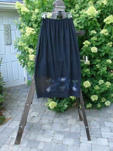 1997 Indra Skirt Florals Obsidian Size 2: A skirt on a rack, with mix-matched colorful chiseled buttons and deep side pockets. Superior vents with loop closures.
