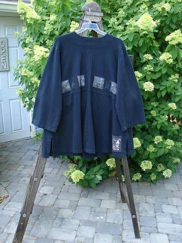 1999 Interlock Stellar Jacket Celtic Flower Black Size 0: A blue jacket with metallic holiday Celtic flower theme paint, large front pockets, and bell sleeves.