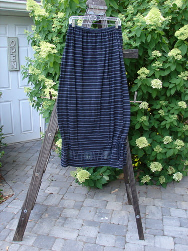 1999 Stripe Box Straight Tie Duo features a blue and white striped top with ribbed V-neck and vented sides, paired with a matching skirt having elastic waist and side ties, displayed on a wooden stand.