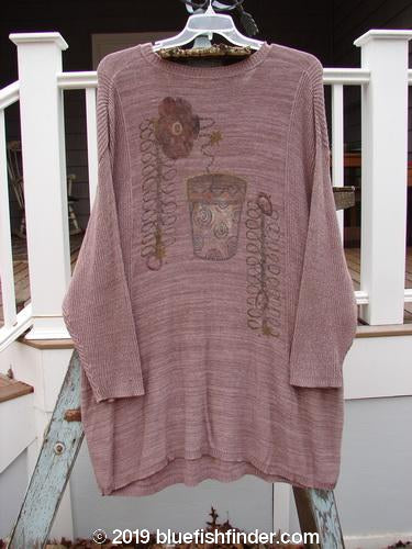 1995 Linear Tunic Top Double Flower Pot Twilight Rose Melange OSFA: Long-sleeved sweater on a swinger with a picture on it. Variegated yarns, contrasting stitchery, ribbed neckline, lower sleeve accents, and dippy hemline. Bust 48, waist 48, hips 50, hem circumference 55, length 36 inches.